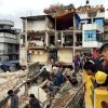 People survey a site damaged by an earthquake, in Kathmandu